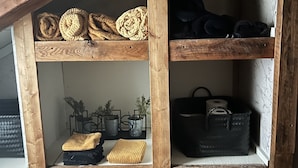 Une étagère en bois avec des paniers et des boîtes de rangement.