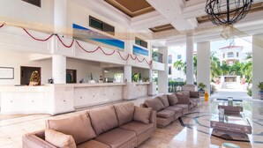 A spacious lobby with a reception desk, a long sofa, and a large chandelier. - Luxury 3 Bdrm Condo in Playacar. Tennis & Golf Close By, Shops Walking Distance! (Playa del Carmen)