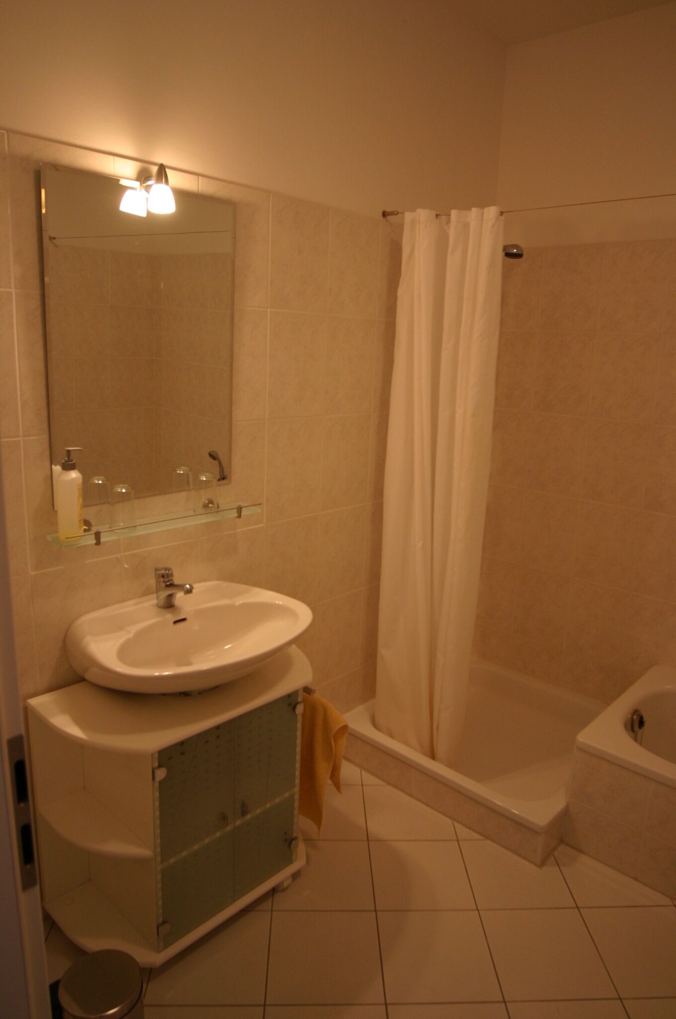Ein Badezimmer mit Waschbecken, Spiegel und Dusche.