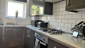 Uma cozinha moderna com fogão a gás, torradeira e pia.
