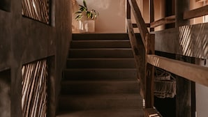 Een houten trap met een plant op de overloop.