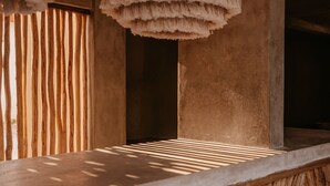 Een houten bar met een uniek herringbone patroon en hangende pendelverlichting.
