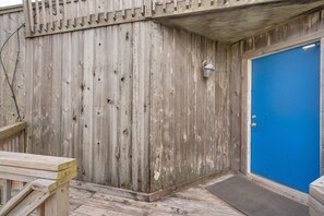 A wooden exterior wall with a blue door, a metal lantern, and a wooden bench. - Gated community with POOL on the beach (Matagorda)