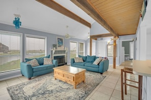 A living room with two blue sofas, a wooden coffee table, and a fireplace.