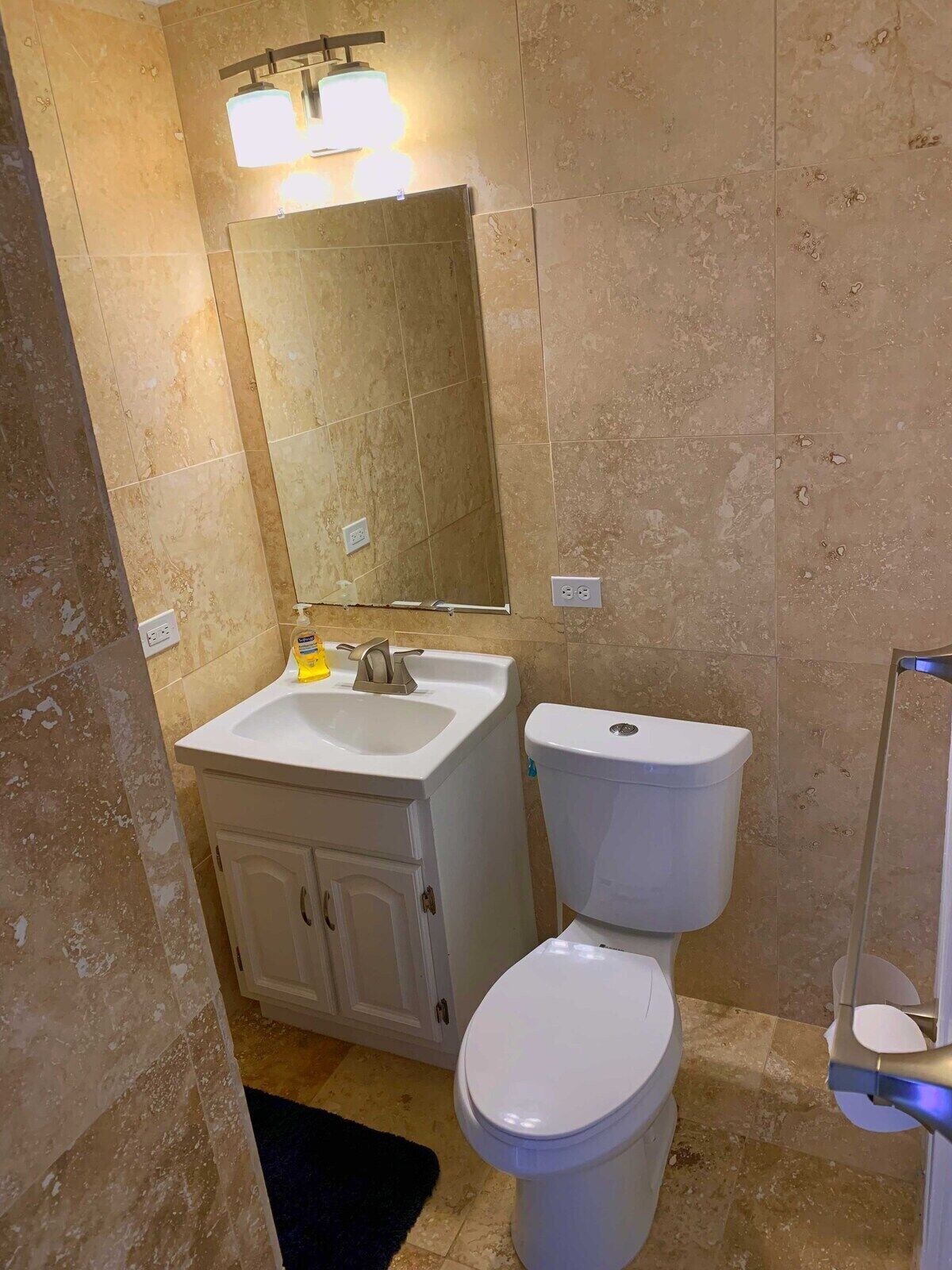 Ein Badezimmer mit einem weißen Waschbecken, einer Toilette und einem Spiegel.