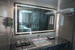 A modern bathroom with a large mirror, a sink, and a towel rack. - Jewel Business Hotel (Kaiping)