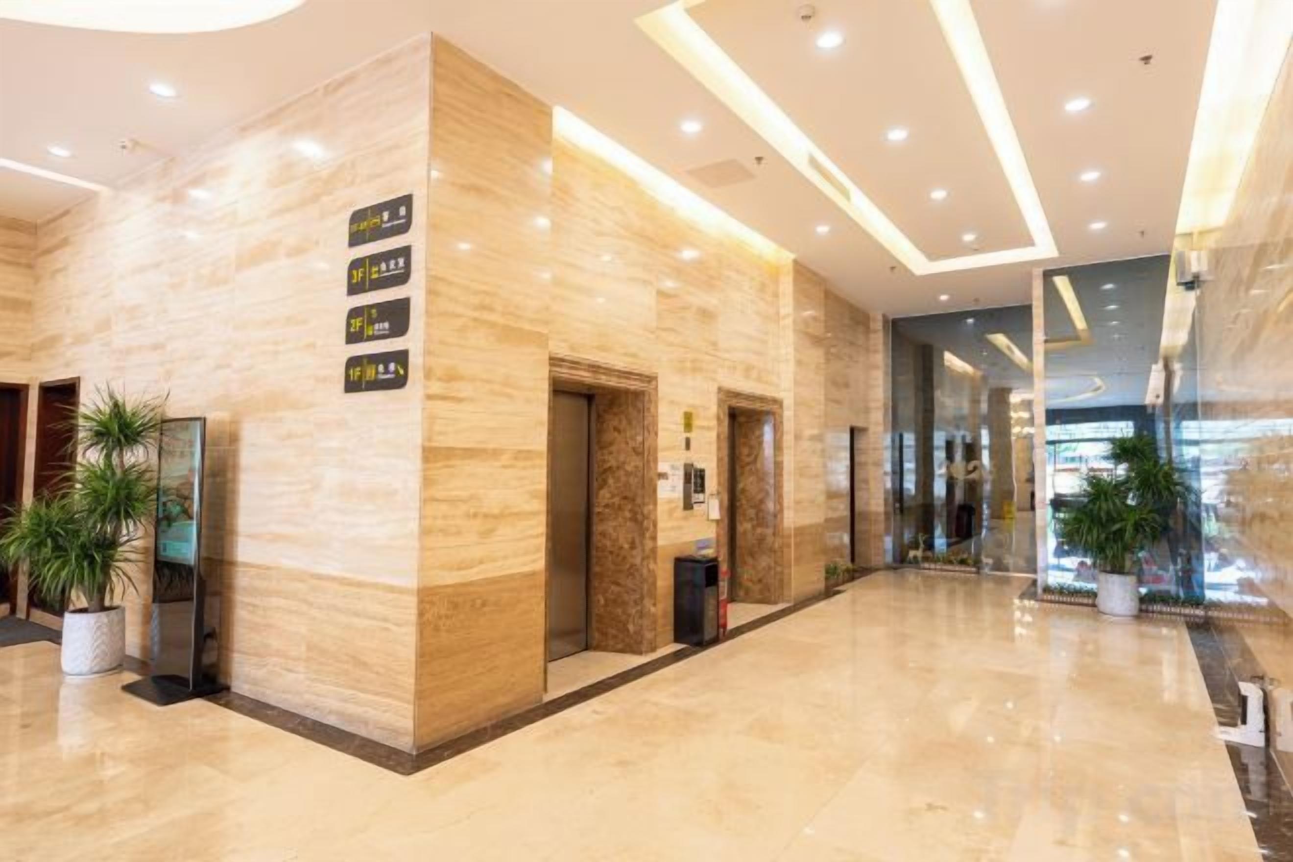 A hotel lobby with a marble reception desk, a plant, and a sign indicating the location.