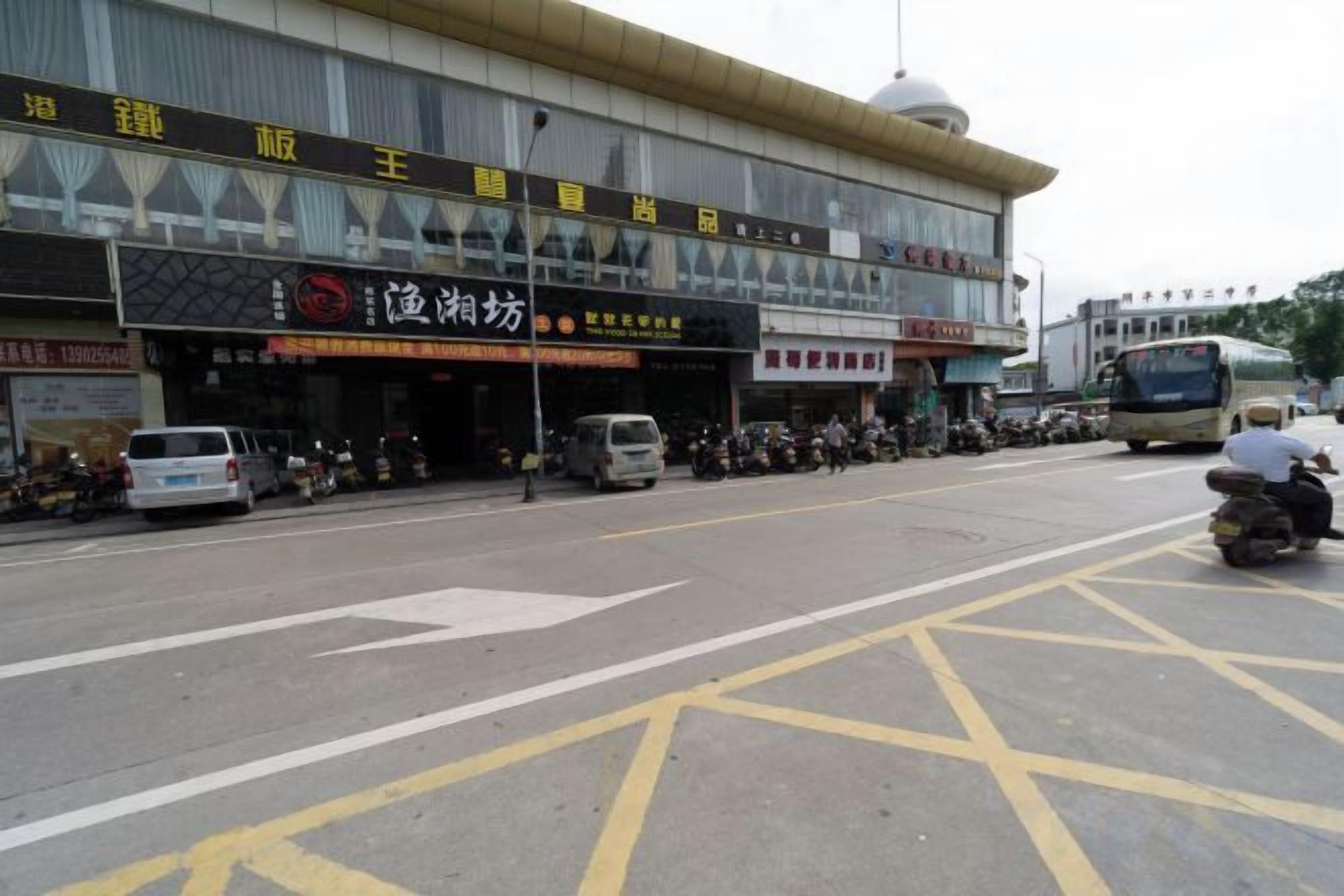 A street with a row of parked motorcycles and a bus.