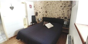 Cozy retreat with a comfortable bed, bedside table, and radiator, featuring a heart-shaped decoration.