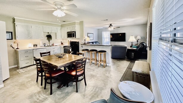 A spacious living area with a dining table, kitchen, and seating area. - Hideaway Haven @ Lake Granbury (Granbury)