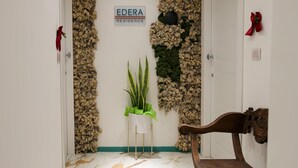 A hallway with a marble floor, a wooden bench, and a door with a sign reading "EDERA RESIDENCE". - Edera Residence  (Naples)