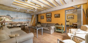 Una sala de estar acogedora con un sofá, sillones, una mesa de centro y un comedor con sillas y una mesa.