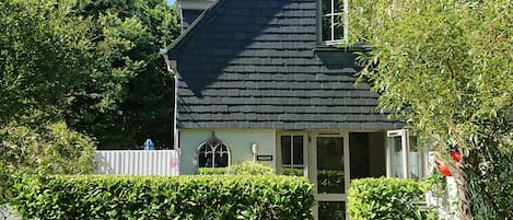 Una casa con techo oscuro, una puerta principal visible y un letrero que dice "WILLOW".
