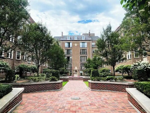 Classic architecture meets serene surroundings in this traditional building, featuring a central entrance and beautifully maintained gardens.