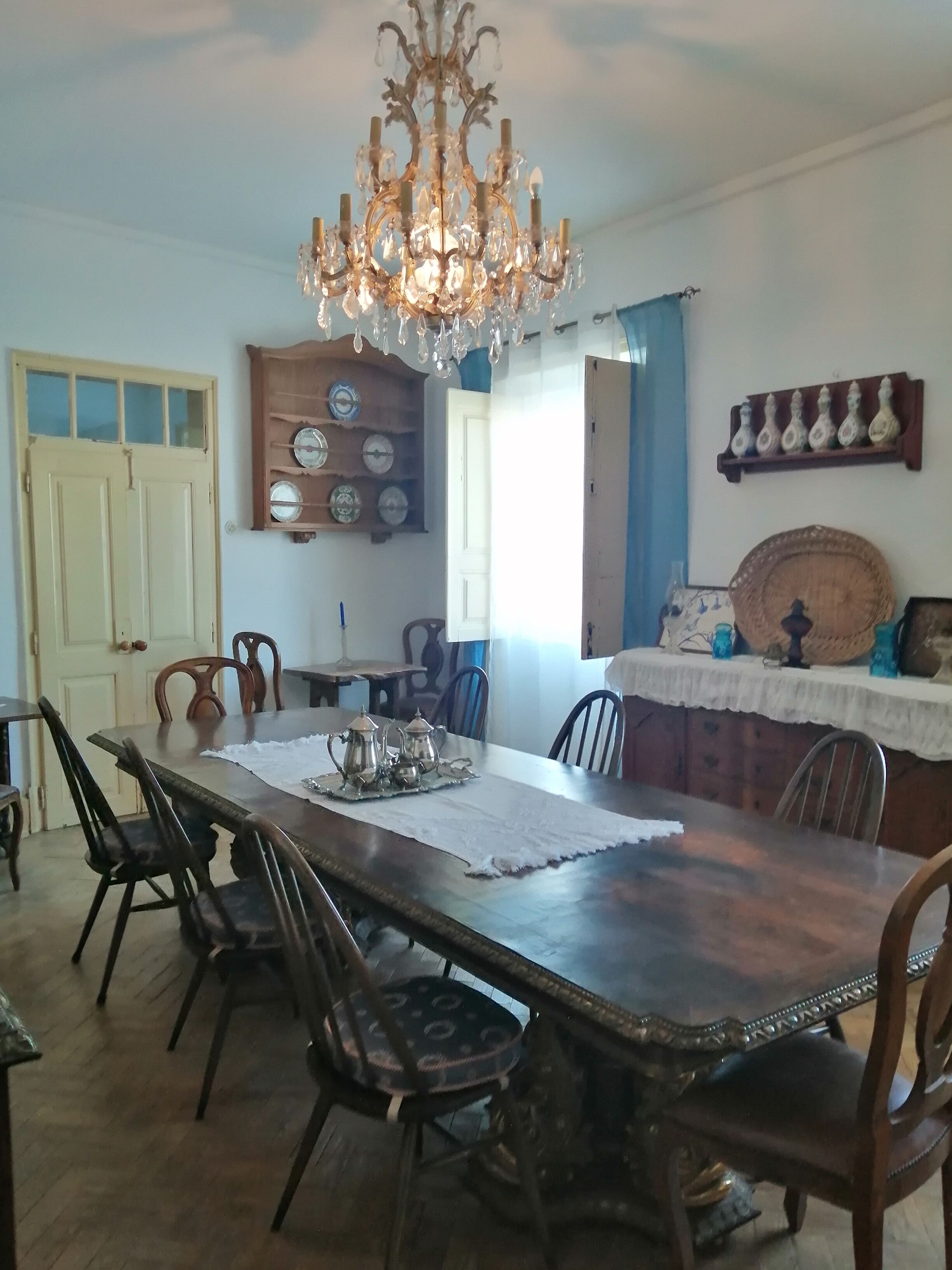 A dining area with a wooden table, chairs, and a chandelier.