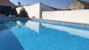 A swimming pool with clear blue water and a tiled floor. - Pias Guesthouse (Serpa)