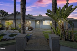 Stroll through the serene garden to the entrance of this single-story house.