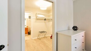 A room with a white dresser, a hanging laundry rack, and a door leading to another room. - ✨One Bedroom Stunning River Views at Fort Lauderdale (Fort Lauderdale)