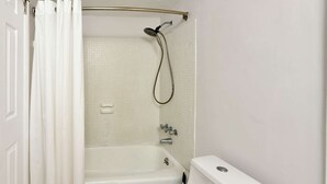 A bathroom with a bathtub, toilet, and shower.