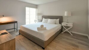 A neatly arranged hotel room with a bed, bedside tables, a desk, and a window. - ✨One Bedroom Stunning River Views at Fort Lauderdale (Fort Lauderdale)