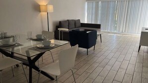 Ein stilvolles Wohnzimmer mit einem Glastisch, einer Couch und einer Stehlampe.