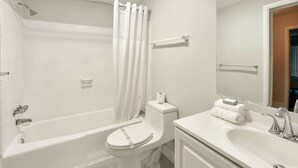 Ein Badezimmer mit Badewanne, Toilette, Waschbecken und Spiegel.