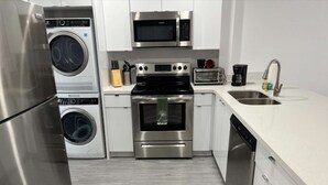 A modern kitchen with stainless steel appliances, a dishwasher, and a microwave. - ✨ New Designer One Bedroom Apartment at Fort Lauderdale (Fort Lauderdale)