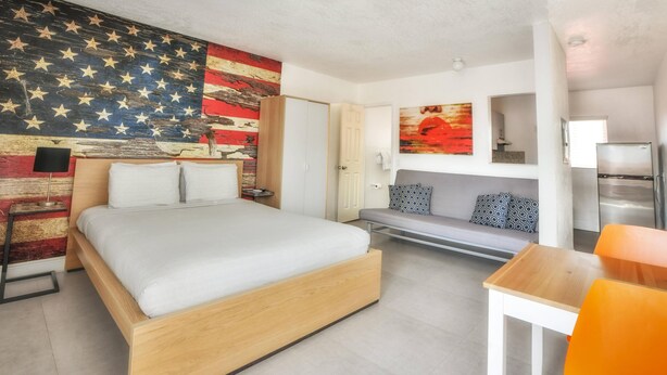 A modern hotel room with a large bed, a desk, and a seating area. - ✨Stunning Wynwood Modern Flat - Full Kitchen (Miami)