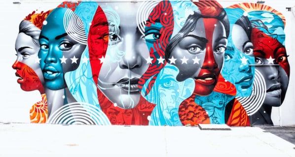 A mural with multiple faces in various artistic styles.