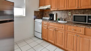 A kitchen with wooden cabinets, a stove, a microwave, and a refrigerator. - ✨Designer Chick Flat w/Full Kitchen (Miami)