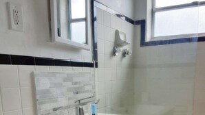 A bathroom with a white sink, dark cabinets, a toilet, and a glass shower enclosure. - ✨Designer Chic Flat/ Full Kitchen Free Parking (Miami)