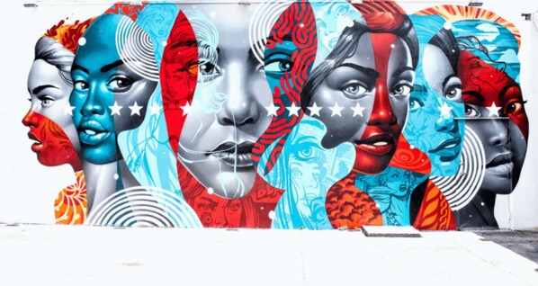 A mural with multiple faces in various artistic styles.