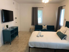A hotel room with a bed, a TV, a small table, and a window with curtains. - ✨ New Studio plus FREE parking fee (Miami)