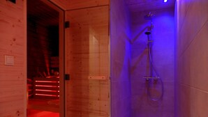 A wooden interior with a glass door leading to a shower area with a handheld showerhead and a floor drain. - Wooden holiday home "Feldrain" on the Baltic Sea - Sauna - 500m to the Baltic Sea beach - Wlan (Zierow)