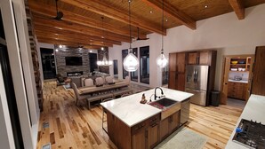 A modern kitchen with wooden cabinets, a large island with a sink, and a built-in oven. - Amazing New 5 Bed Home next to the Columbia River. Sleeps 10 adults & 6 Kids (Stevenson)