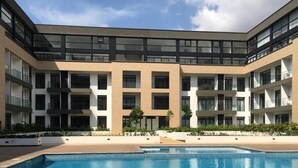 Un edificio moderno con piscina al frente.