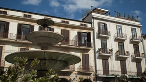 A multi-story building with balconies and a central fountain. - b&b l'Incanto (Cava de' Tirreni)