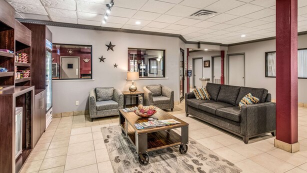A modern living room with a sofa, armchairs, a coffee table, and a bookshelf. - MainStay Suites Ozona I-10 (Ozona)
