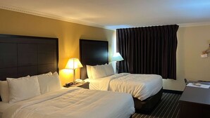 A hotel room with two beds, a desk, a lamp, a telephone, and a window with curtains. - MainStay Suites Ozona I-10 (Ozona)