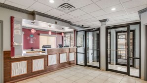 A hotel reception area with a marble floor, a reception desk, and a glass door entrance. - MainStay Suites Ozona I-10 (Ozona)