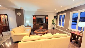 Una sala de estar con sofá, mesa de centro, televisor y chimenea.