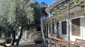 Un edificio con un área exterior techada, una escalera y un balcón.