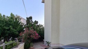 Une voiture est garée dans une allée, et un chemin pavé mène à un bâtiment.