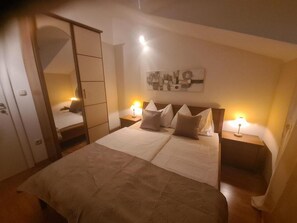 Relax in a spacious room with a large bed, wardrobe, and wall-mounted artwork.