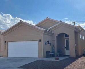 Stylish home with a gabled roof and symmetrical design, featuring decorative star-shaped elements and a well-manicured front yard.