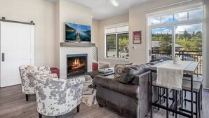 Una sala moderna con chimenea, sofás de cuero y un comedor con vistas.