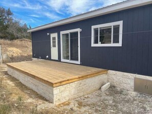 A modern building with a wooden deck, a door, and a window.