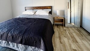 Une chambre à coucher avec un lit, une table de chevet et une armoire.