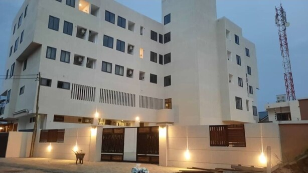 Un immeuble à plusieurs étages doté d’une architecture moderne, caractérisé par une structure verticale centrale et de nombreux balcons.