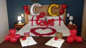 Habitación de hotel con cama, almohadas y una decoración con forma de corazón.